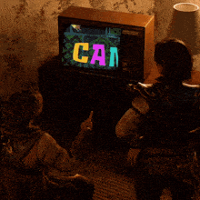 two people sitting in front of a television that says vg