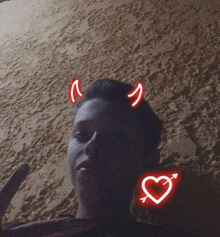 a person with devil horns and a heart with an arrow