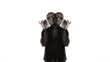 a man in a black shirt and sunglasses is standing in front of a mirror