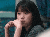 a close up of a girl 's face with her hand on her chin