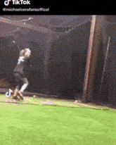 a person is swinging a golf club at a ball in a cage .