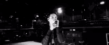 a black and white photo of a man singing into a microphone