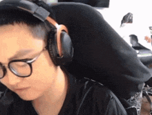 a man wearing glasses and headphones looks at something