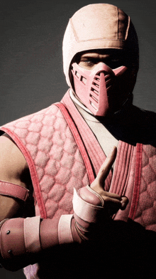 a man wearing a pink helmet and gloves is giving a peace sign