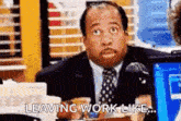 a man in a suit and tie is sitting at a desk and saying `` leaving work like ... '' .