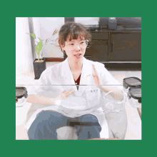 a woman in a lab coat and glasses sits at a table with containers