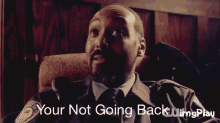 a man sitting in a chair with the words " your not going back " on the bottom