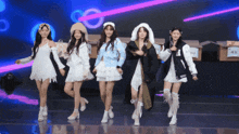 a group of girls are dancing on a stage and one of them is wearing a varsity jacket with the letter u on it