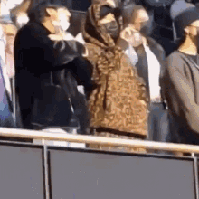 a group of people wearing face masks are standing next to each other in a stadium .