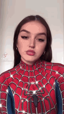 a woman is wearing a spiderman costume and making a funny face .