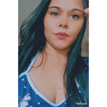 a woman wearing a blue polka dot top has a selfie taken with the app yuface