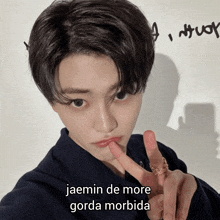 a young man giving a peace sign with the words jaemin de more gorda morbida written in the background