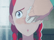 a close up of a person cleaning a girl 's face with a cloth