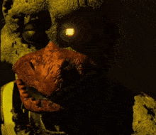 a close up of a monster with a glowing eye and sharp teeth