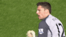 a soccer player with the number 1 on his jersey stands on the field