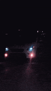 a white car is parked in a dark parking lot at night