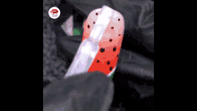 a close up of a person painting a watermelon on a nail .