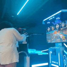 a woman is playing a video game with a rifle and a screen that says reframe ra