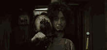 a man with blood on his face is holding a knife