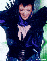 a woman with a tattoo on her chest is wearing a purple and black costume