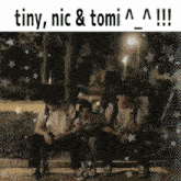 a group of people sitting next to each other with the words tiny nic & tomi written above them
