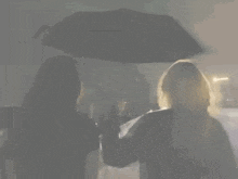 two women are holding an umbrella in the rain with the words `` it 's really you on my mind '' written above them .