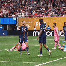 soccer players on a field with one wearing a qatar shirt