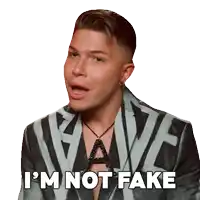 a man in a suit says " i 'm not fake " with his mouth open