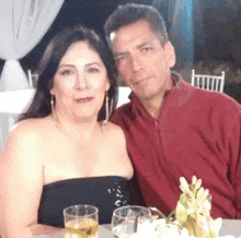 a man and a woman posing for a picture with glasses of beer in front of them