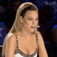 a woman sitting in front of a microphone with the word talent on the bottom right