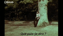 a man standing next to a tree with the words que puis-je dire written on the screen