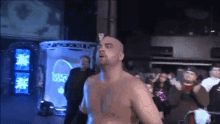 a man without a shirt stands in front of a sign that says big east