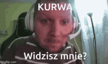 a man wearing headphones and a microphone says kurwa widzisz mnie