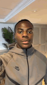 a man wearing a nike jacket is taking a selfie .