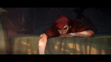 a woman with red hair is laying on a bed with a tattoo on her arm