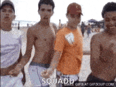 a group of young men are standing next to each other on the beach .