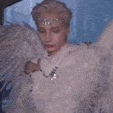 a close up of a person wearing wings and a crown
