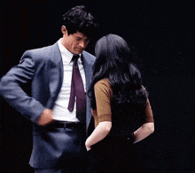 a man in a suit and tie is dancing with a woman .