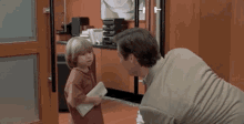 a man and a little girl are standing next to each other in a room .