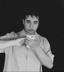 a man in a white shirt is holding a piece of paper in his hand