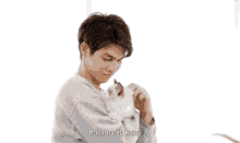 a man is holding a small white cat in his arms and says " rainy " at the bottom