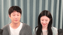 a man and a woman are sitting next to each other with their eyes closed .