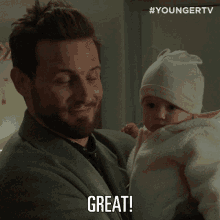 a man holding a baby with the word great written on his face
