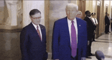 a man in a blue suit and purple tie is standing next to another man