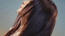 a close up of a woman 's face with her hair blowing in the wind