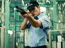 a man wearing a security hat holds a shotgun