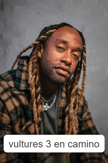 a man with dreadlocks and the words vultures 3 en camino