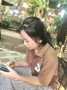 a girl wearing a brown shirt that says me on it