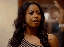 a woman wearing a black and white striped dress looks angry