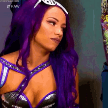 a woman with purple hair is wearing a black and purple outfit and sunglasses .